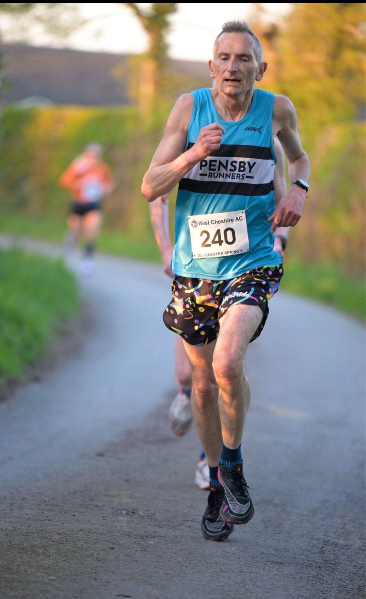 Mark in his Pensby Vest running in a road race with very colourful shorts