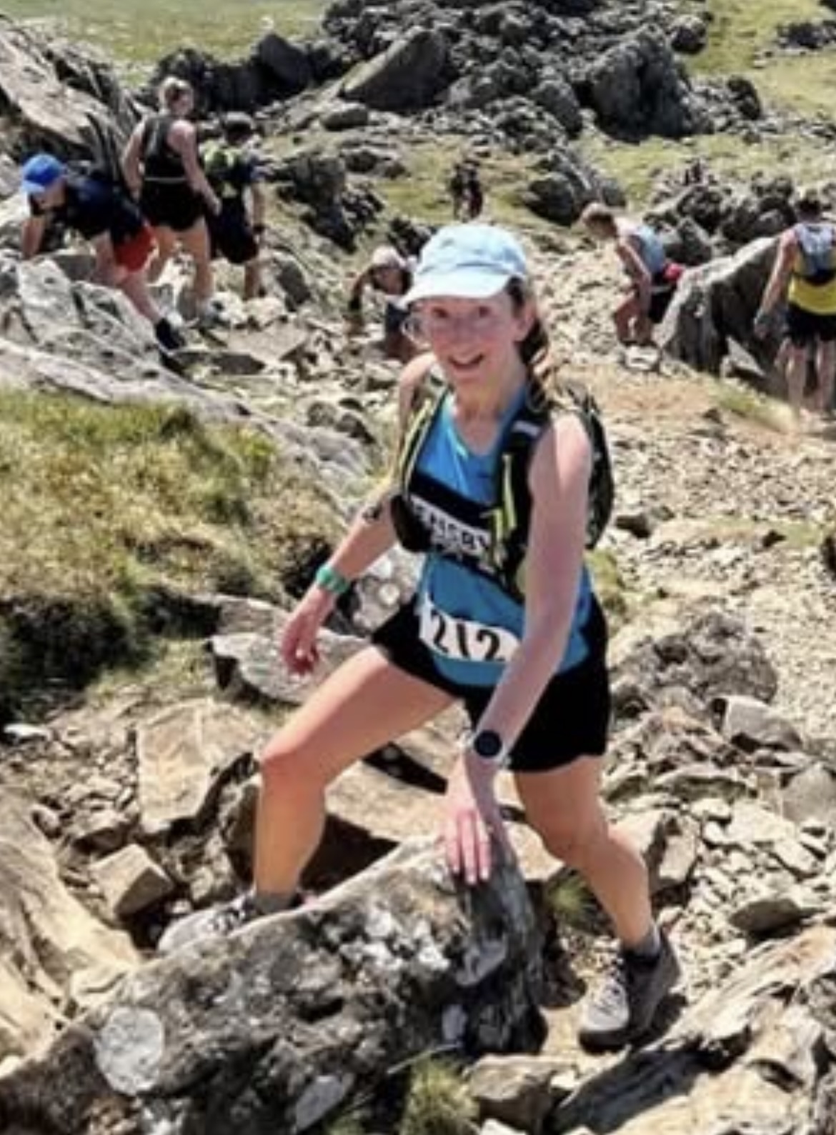 Wendy in her pensby vest up a mountain on a sunny day